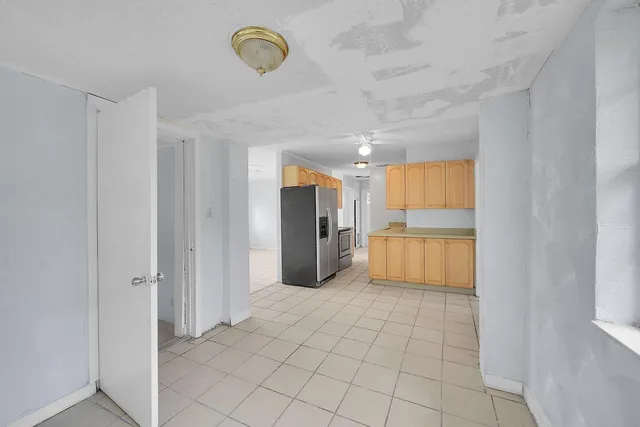 a view of a refrigerator in kitchen and a window