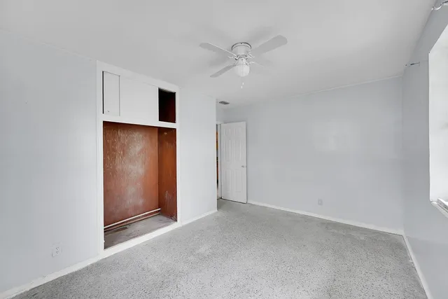 an empty room with closet and windows
