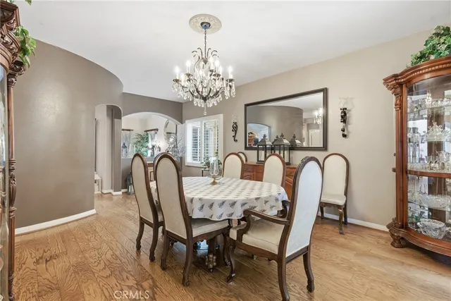 a dining room with furniture a chandelier and wooden floor