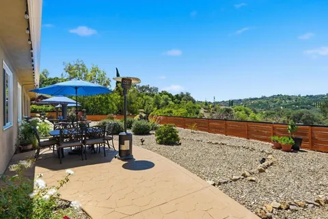 a view of swimming pool with outdoor seating and mountain view in back