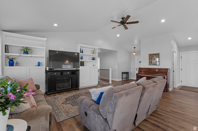 75 North 100th Street West Fillmore, UT 84631 - Photo 6 of 62 Living room with built in features, vaulted ceiling, wood finished floors, ceiling fan, and a glass covered fireplace