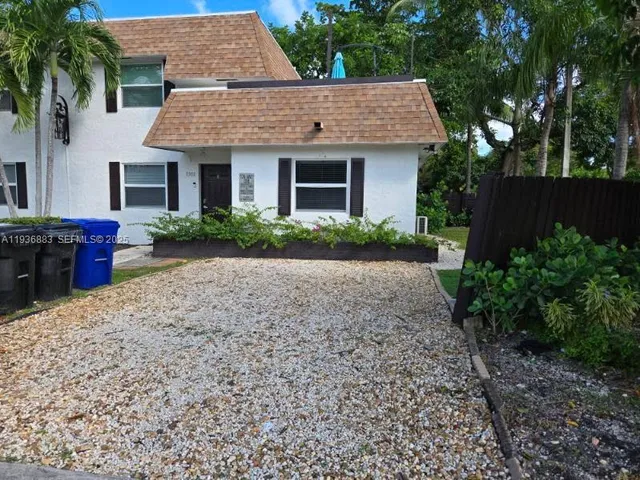a front view of a house with garden and yard