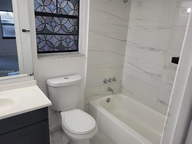 a white toilet sitting next to a bath tub