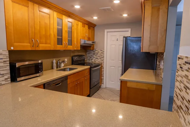 a kitchen with stainless steel appliances a refrigerator sink and stove
