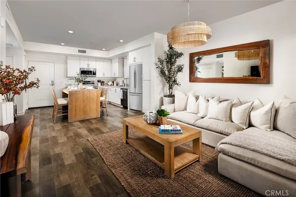 a living room with furniture kitchen view and a potted plant