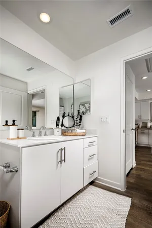 a view with a sink and mirror with wooden floor