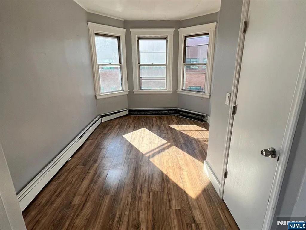 489 Market Street, Unit 2 Paterson, NJ 07501 - Photo 6 of 6 an empty room with wooden floor and windows