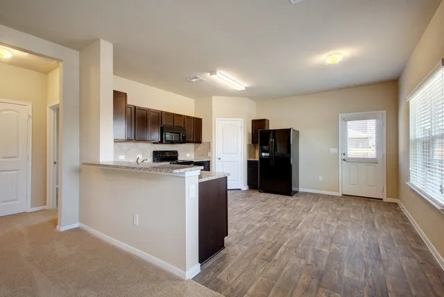 a kitchen with stainless steel appliances granite countertop a refrigerator stove and oven