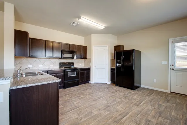a kitchen with granite countertop stainless steel appliances and wooden cabinets