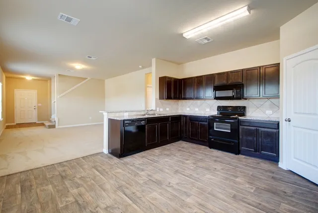 a view of bedroom and hall with wooden floor