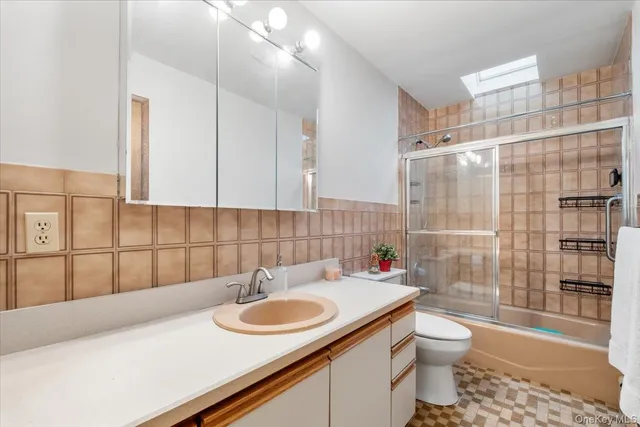 a bathroom with a sink toilet vanity and shower