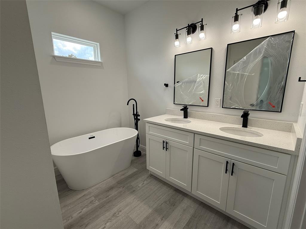 4875 Southwest 159th Lane Ocala, FL 34473 - Photo 13 of 32 a bathroom with a double vanity sink mirror and bathtub