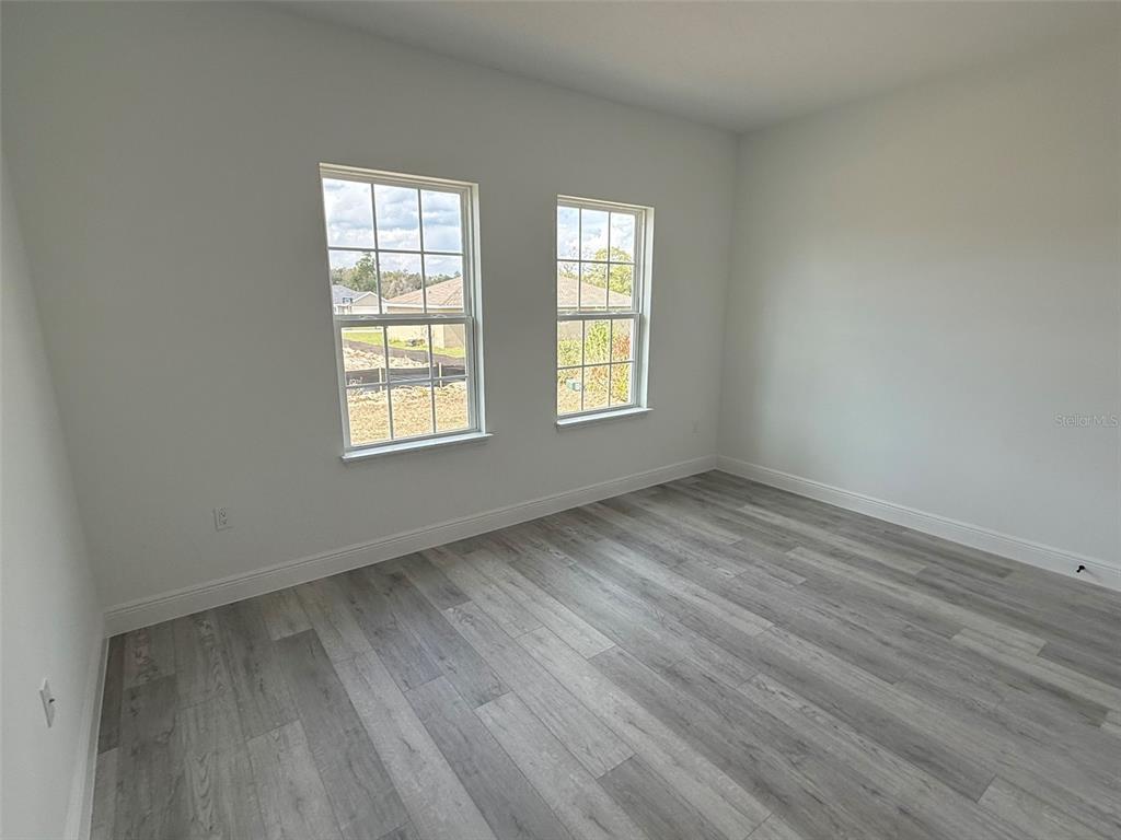 4875 Southwest 159th Lane Ocala, FL 34473 - Photo 18 of 32 an empty room with wooden floor and windows