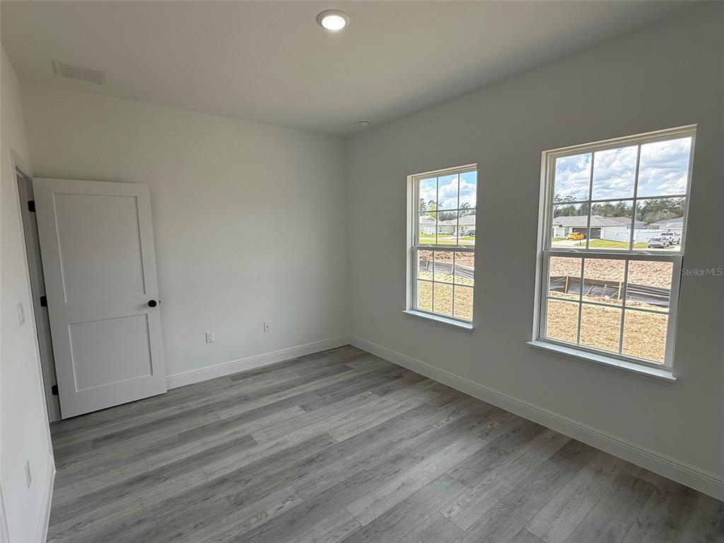4875 Southwest 159th Lane Ocala, FL 34473 - Photo 19 of 32 a view of an empty room with wooden floor and a window
