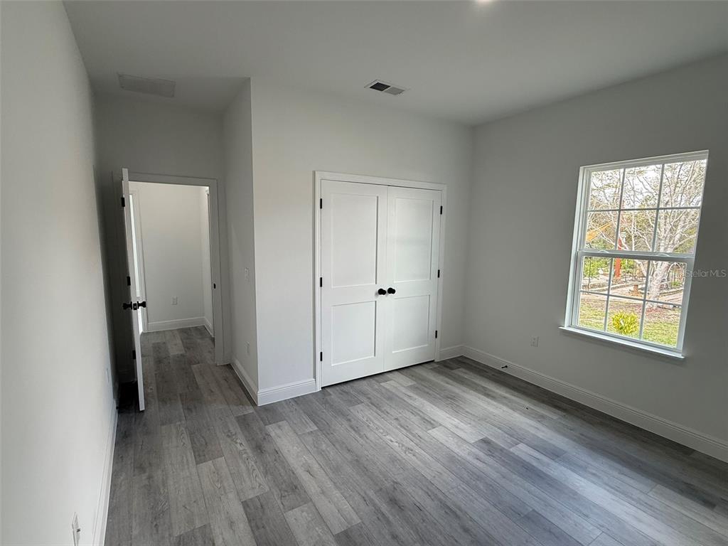 4875 Southwest 159th Lane Ocala, FL 34473 - Photo 21 of 32 an empty room with wooden floor and windows