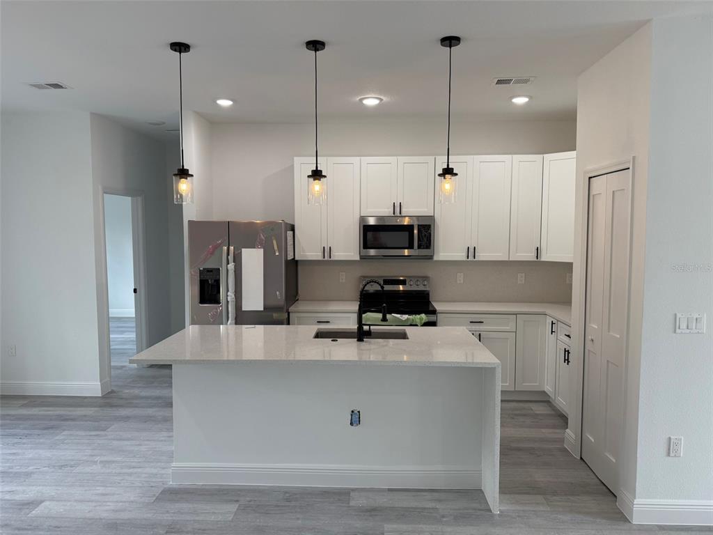 4875 Southwest 159th Lane Ocala, FL 34473 - Photo 4 of 32 a large kitchen with stainless steel appliances a large counter top space a sink a refrigerator and a window