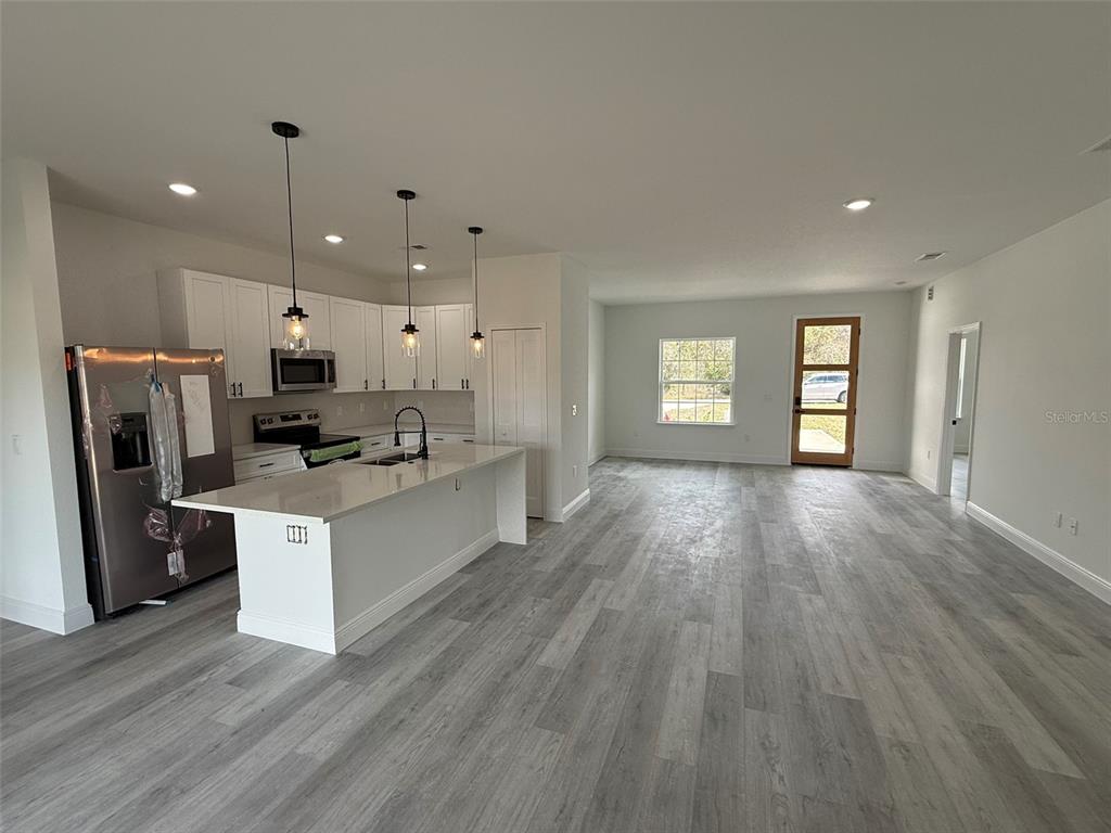 4875 Southwest 159th Lane Ocala, FL 34473 - Photo 6 of 32 a large kitchen with stainless steel appliances granite countertop a refrigerator oven a sink dishwasher and a stove with wooden floor