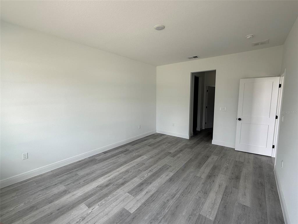 4875 Southwest 159th Lane Ocala, FL 34473 - Photo 7 of 32 a view of an empty room with wooden floor