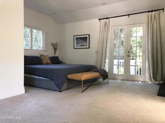 a bedroom with a bed and a large window