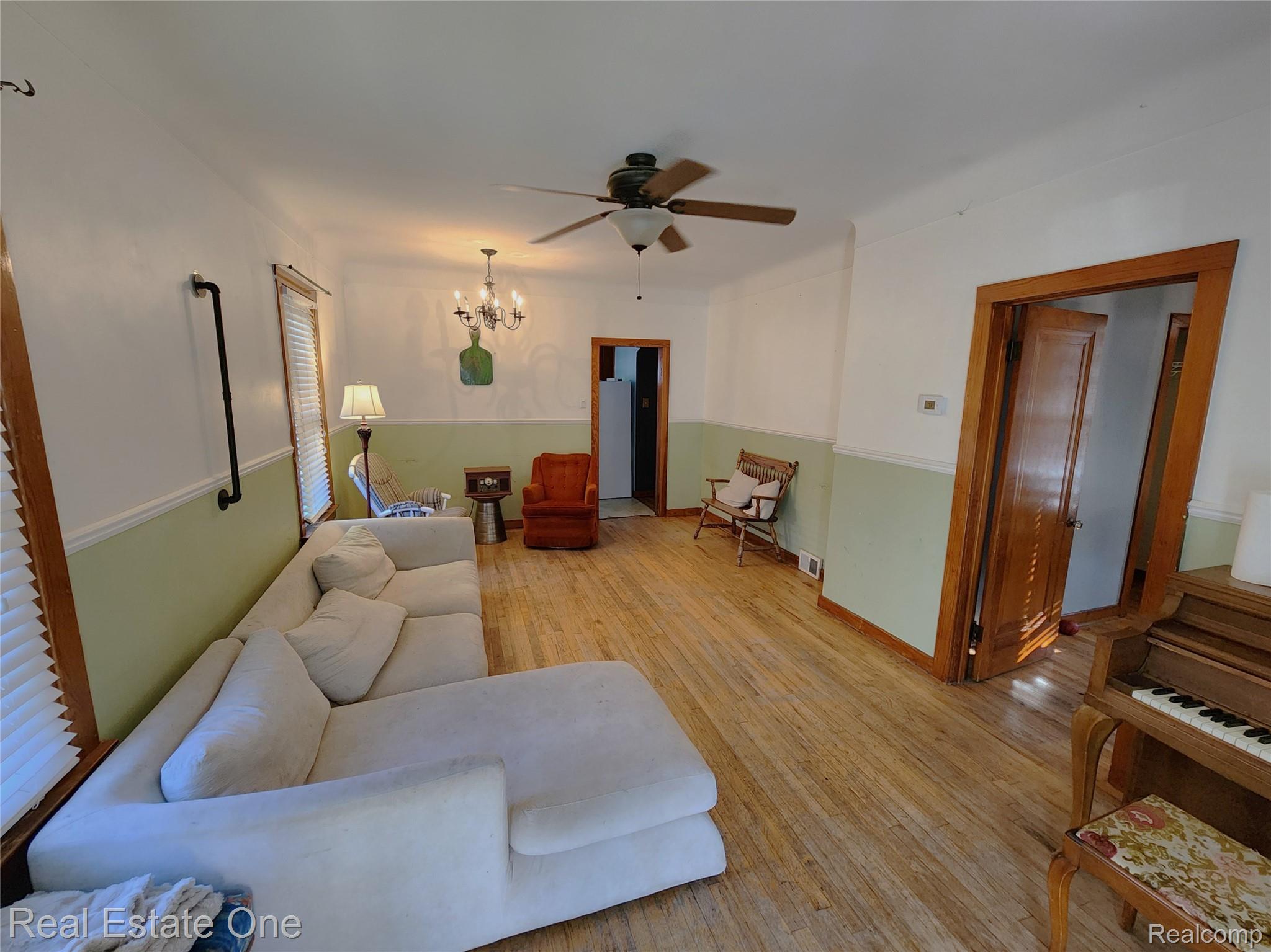 2153 Wiltshire Road Berkley, MI 48072 - Photo 3 of 18 Spacious room featuring wood-finish flooring, white and sage green two-tone wall treatment, and natural wood window trim