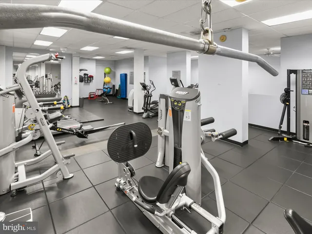 a front view of a building with lot of cars and trees