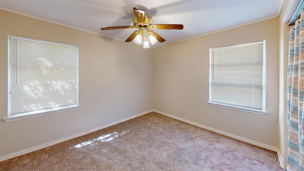 12225 Schroeder Road Dallas, TX 75243 - Photo 18 of 40 Neutral wall tones, carpet flooring, two windows with blinds, and a ceiling fan with integrated lighting