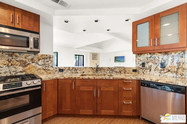 a large kitchen with stainless steel appliances granite countertop a stove and a sink