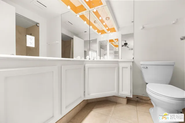 an empty room with chandelier fan and windows