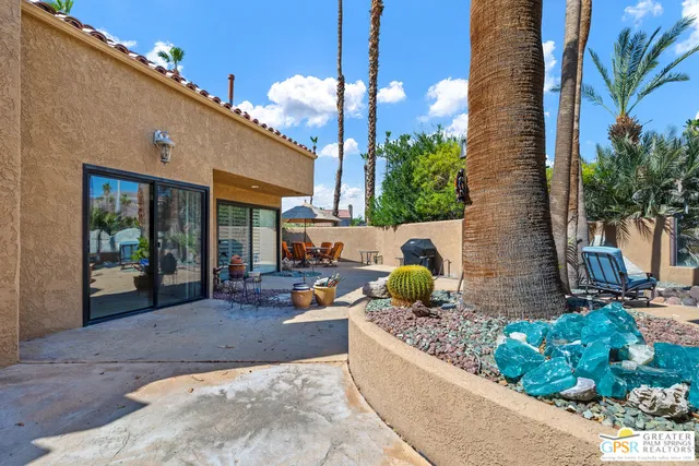 a backyard of a house with table and chairs