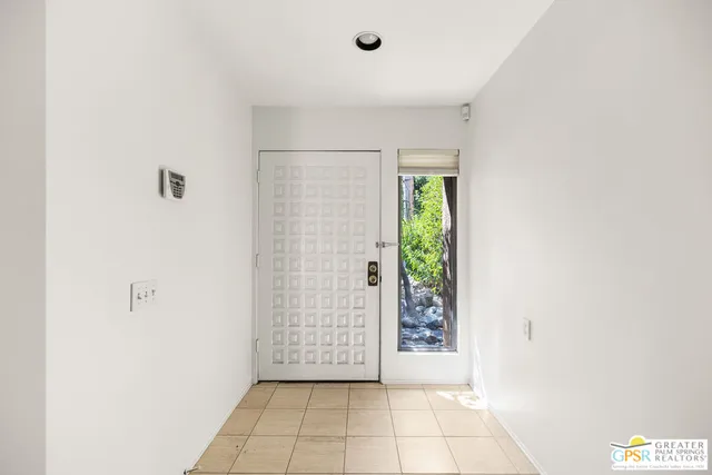 a view of a big room with windows and chandelier