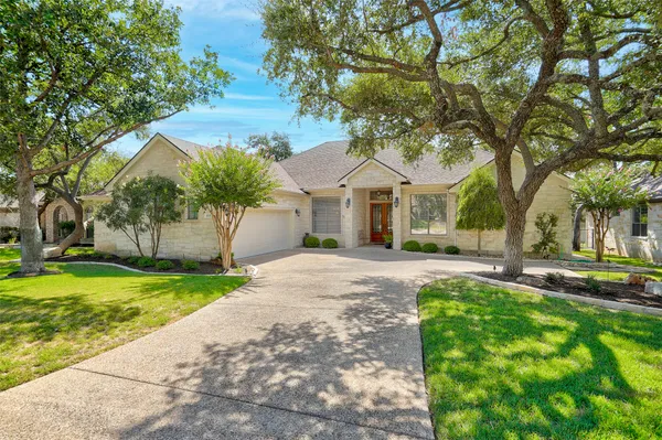 a front view of a house with a yard and trees