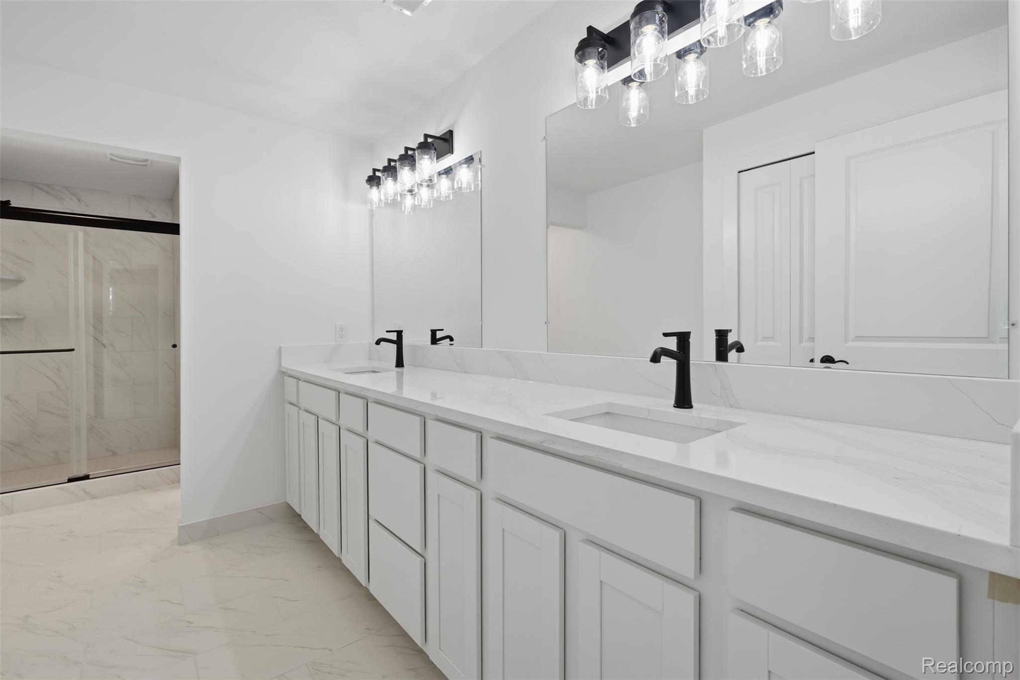 4655 Denton Road Canton, MI 48188 - Photo 26 of 54 Dual vanity with white cabinetry, integrated sinks, black fixtures, and a large mirror