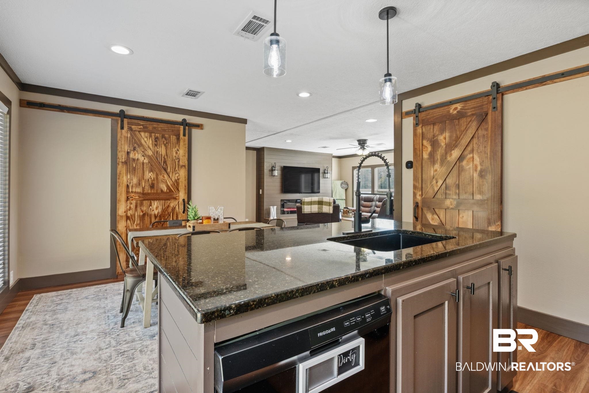 15080 Starlight Avenue Wilmer, AL 36587 - Photo 12 of 29 Kitchen with sink, hardwood / wood-style flooring, dark stone countertops, pendant lighting, and a barn door