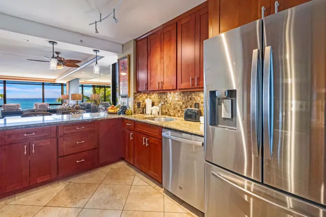 a kitchen with stainless steel appliances granite countertop a refrigerator and a sink