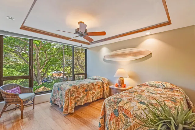 a bedroom with two beds and a large window