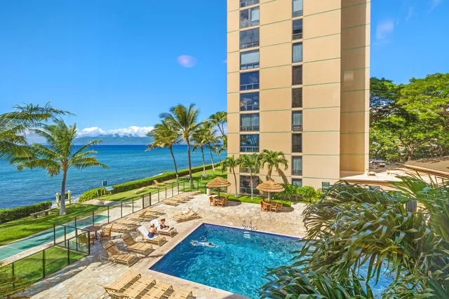 a view of a tall white building with a plant