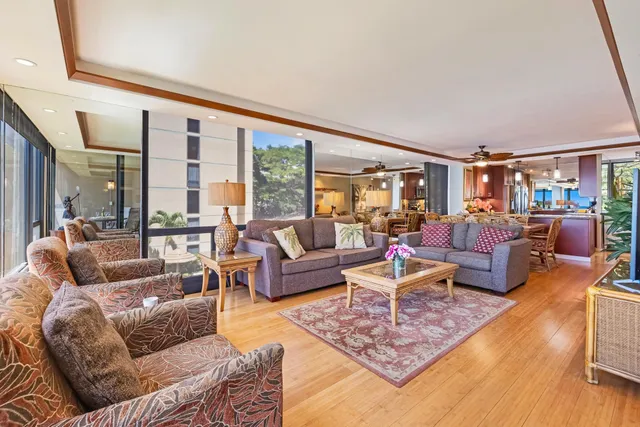 a living room with furniture large windows and wooden floor