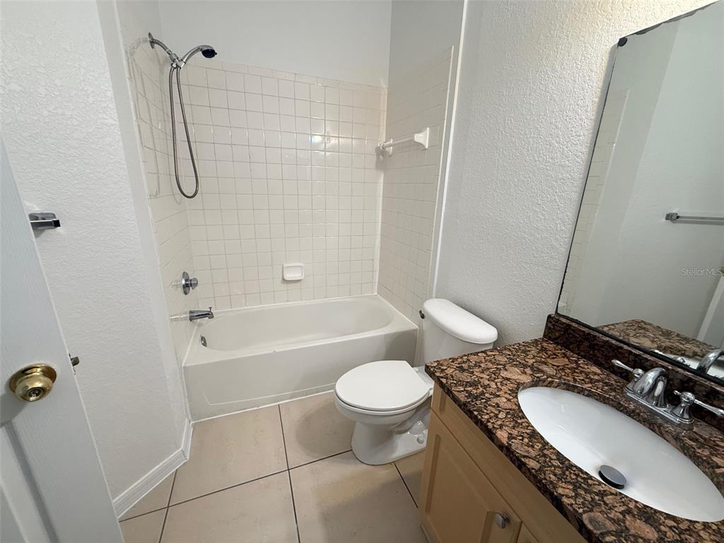 3611 Conroy Road, Unit 825 Orlando, FL 32839 - Photo 12 of 27 a bathroom with a granite countertop sink toilet and shower