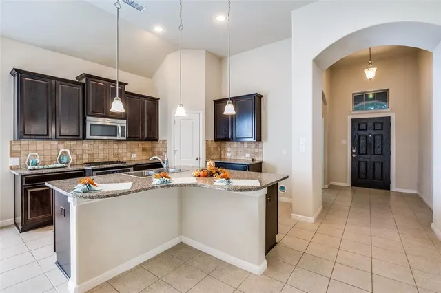 a kitchen with stainless steel appliances a stove sink microwave and cabinets