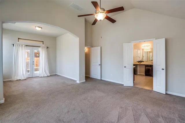 an empty room with fan and entrance