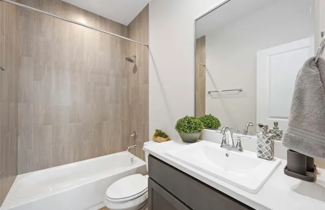 a bathroom with a sink a toilet a mirror and shower