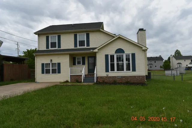 a view of a house with a big yard and large trees