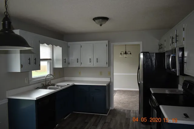 a kitchen with a sink a refrigerator and cabinets
