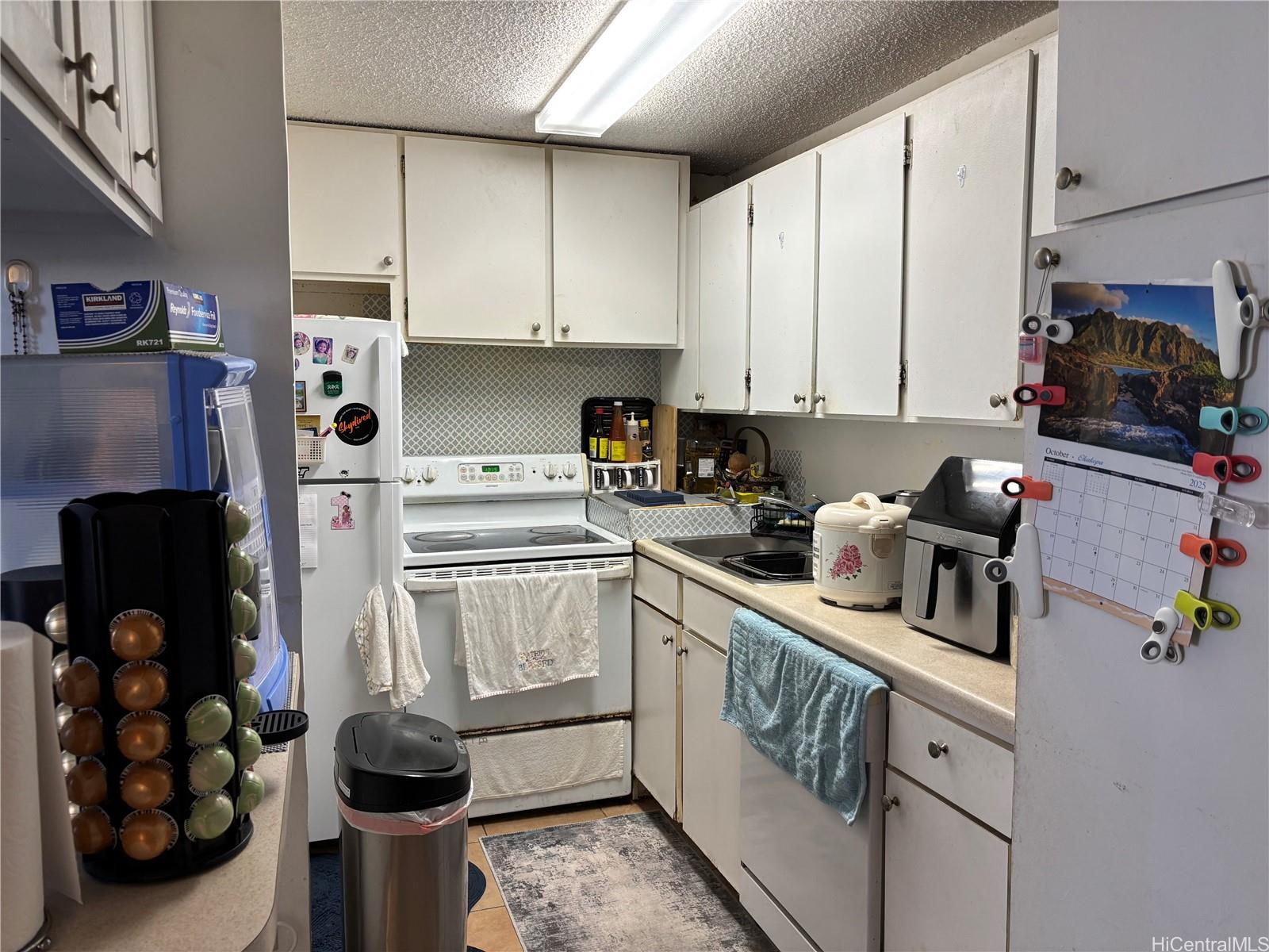 3215 Ala Ilima Street, Unit B404 Honolulu, HI 96818 - Photo 2 of 11 a kitchen with a sink cabinets and appliances