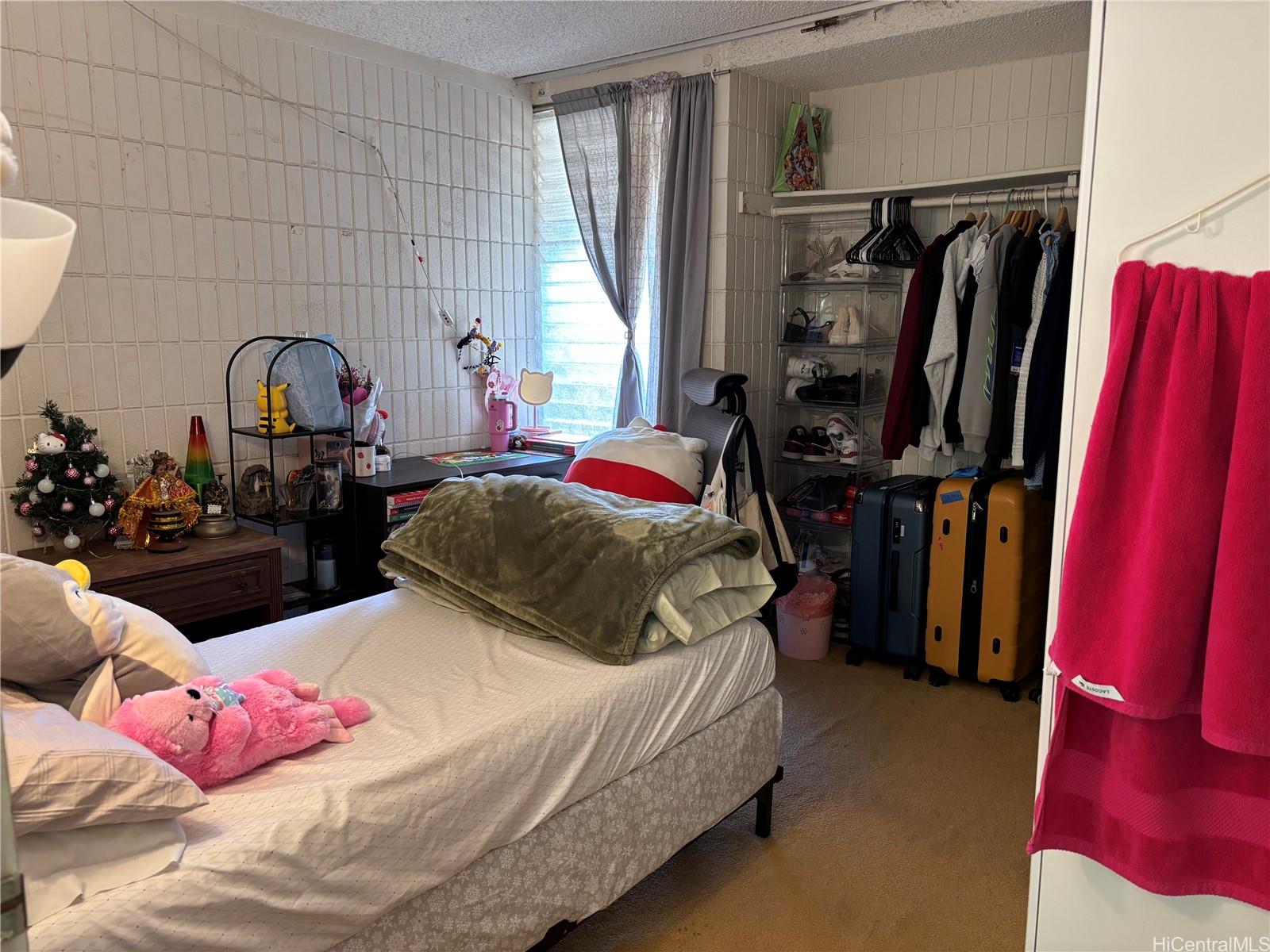 3215 Ala Ilima Street, Unit B404 Honolulu, HI 96818 - Photo 7 of 11 a bedroom with a bed and a mirror