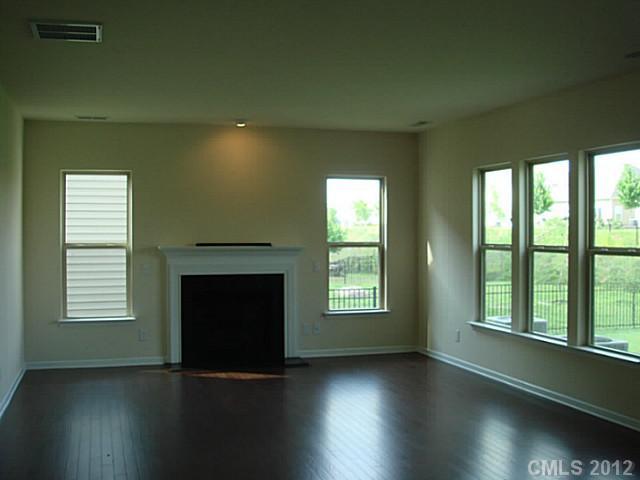 1500 Ridgehaven Road, Unit 147 Waxhaw, NC 28173 - Photo 3 of 14 an empty room with wooden floor fireplace and windows