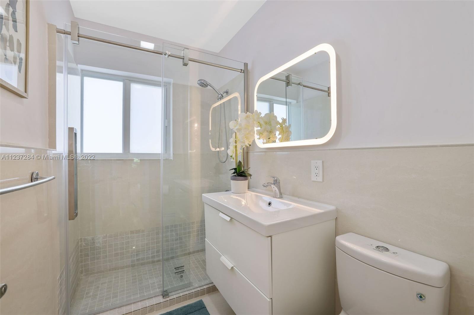 440 Blue Road Coral Gables, FL 33146 - Photo 15 of 20 a bathroom with a sink a toilet and a mirror