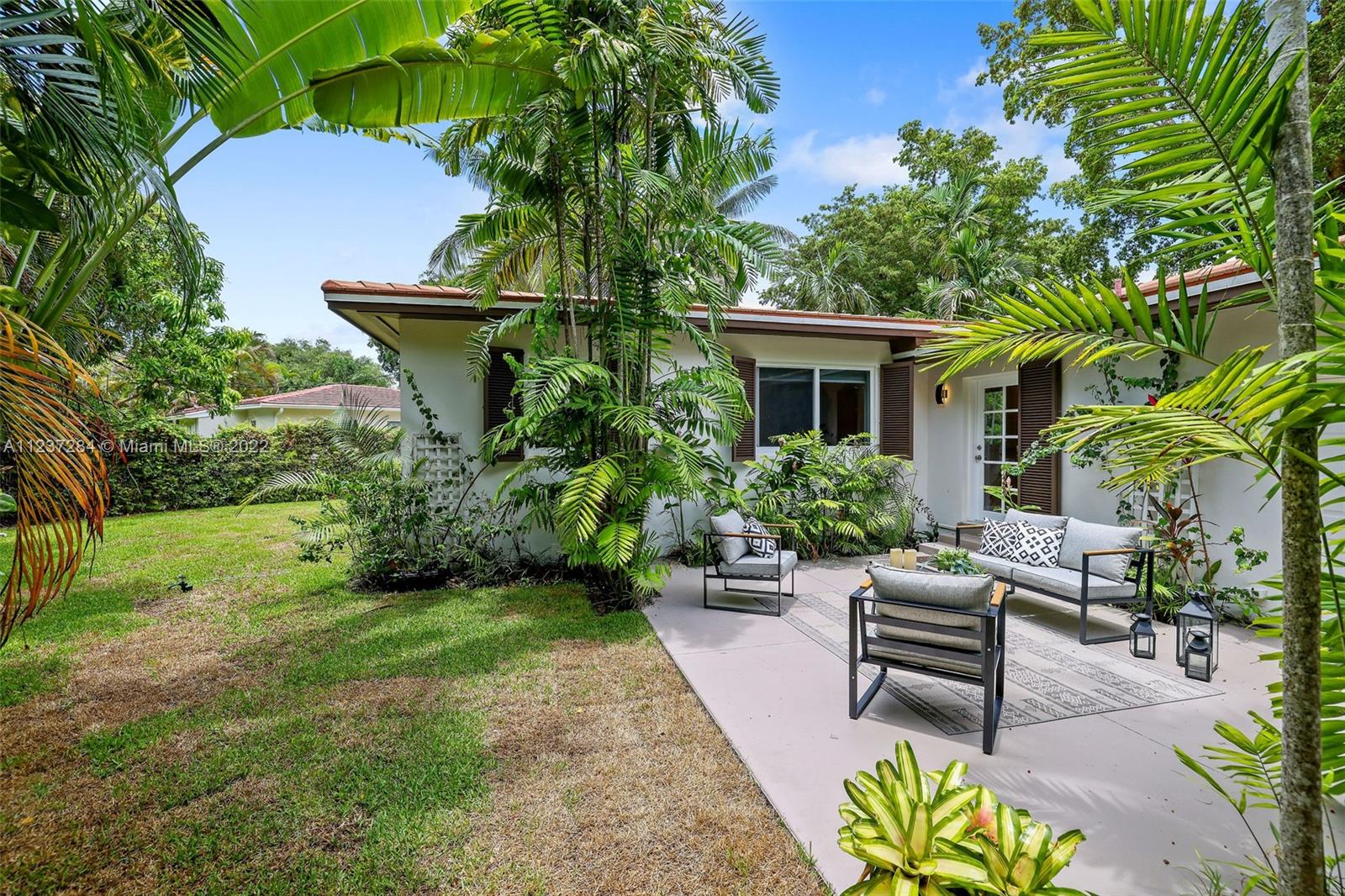 440 Blue Road Coral Gables, FL 33146 - Photo 17 of 20 a view of a chair and table in the garden