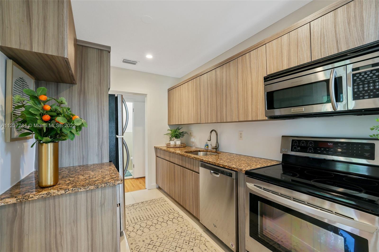 440 Blue Road Coral Gables, FL 33146 - Photo 9 of 20 a kitchen with stainless steel appliances a stove a microwave a sink and cabinets