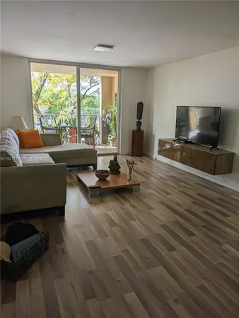 a living room with furniture flat screen tv and a large window